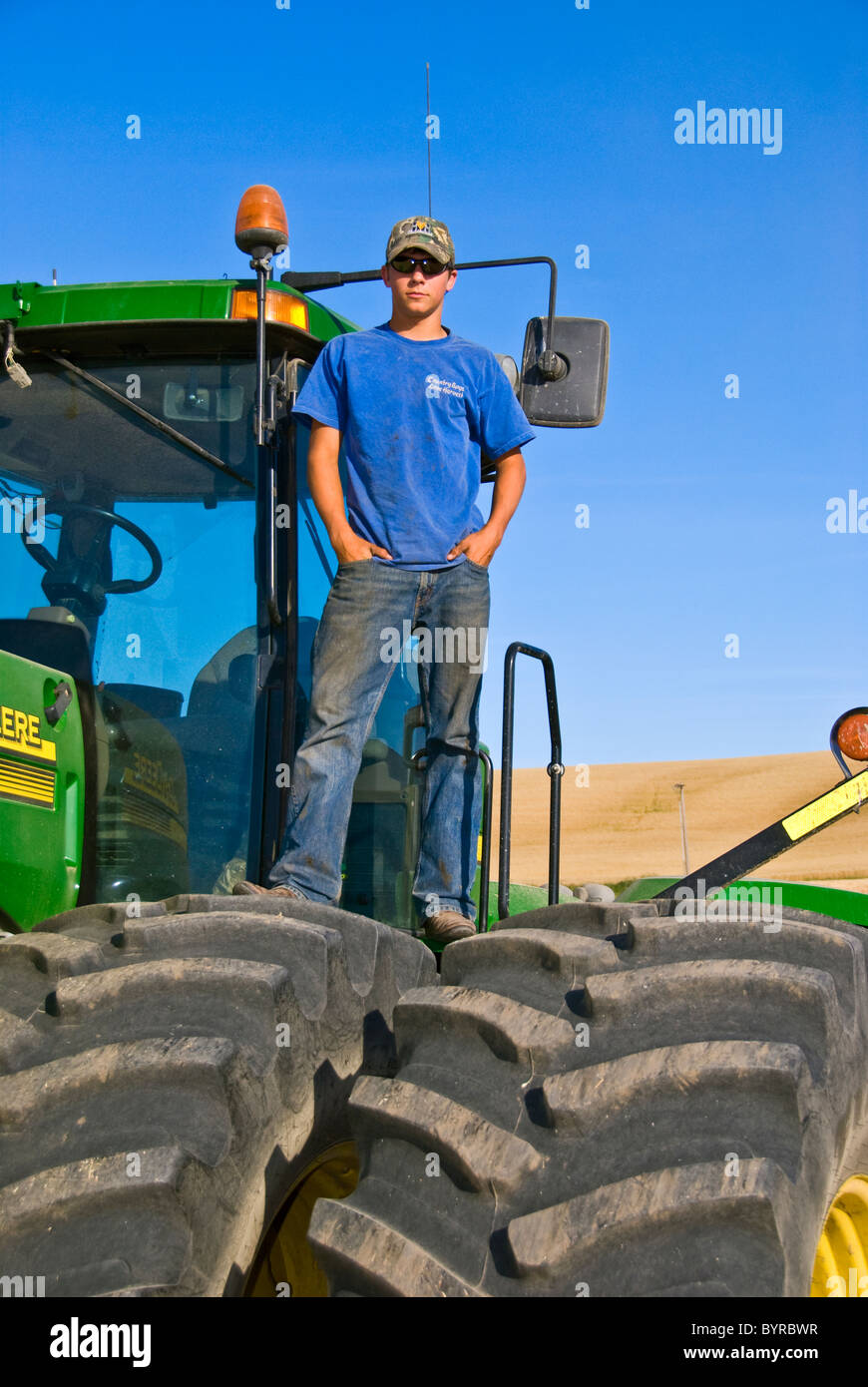 Un giovane agricoltore in cima il suo trattore durante una breve pausa da raccolto nella regione di Palouse / vicino al Pullman, Washington, Stati Uniti d'America. Foto Stock