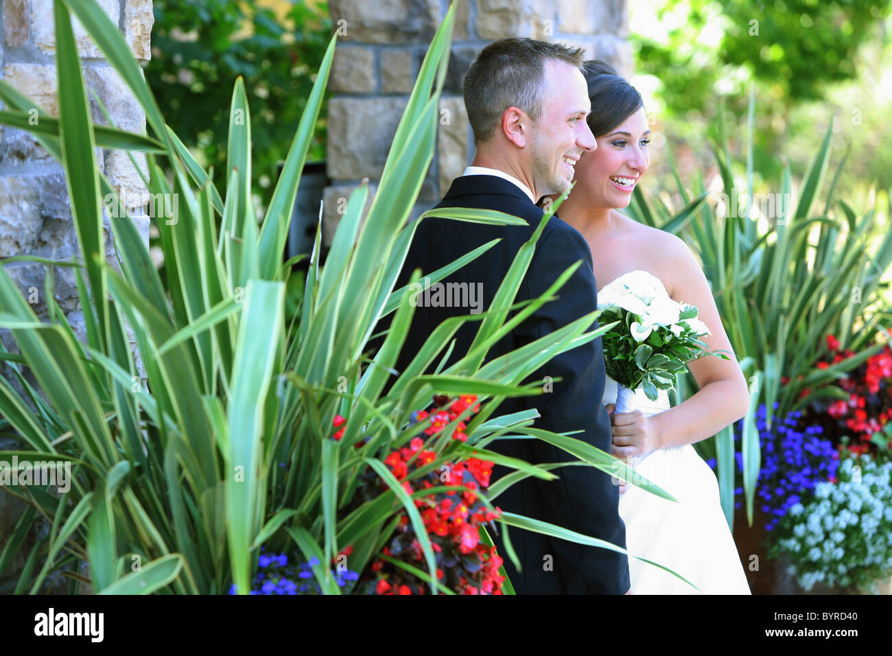 La sposa e lo sposo che posano per una foto in un'area giardino; troutdale, Oregon, Stati Uniti d'America Foto Stock