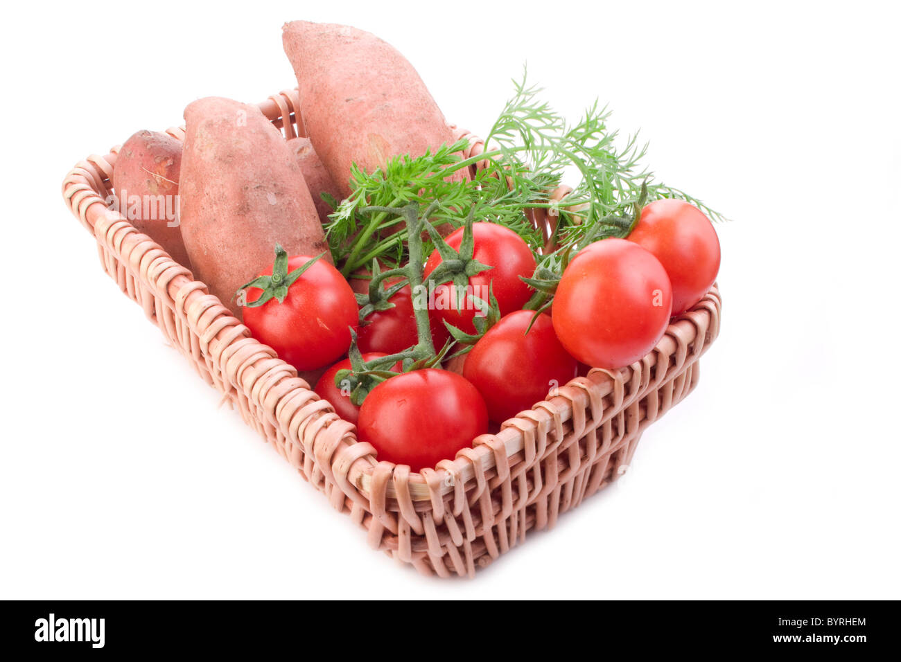 Cesto in legno di crudo fresco pomodori patate e carote Foto Stock