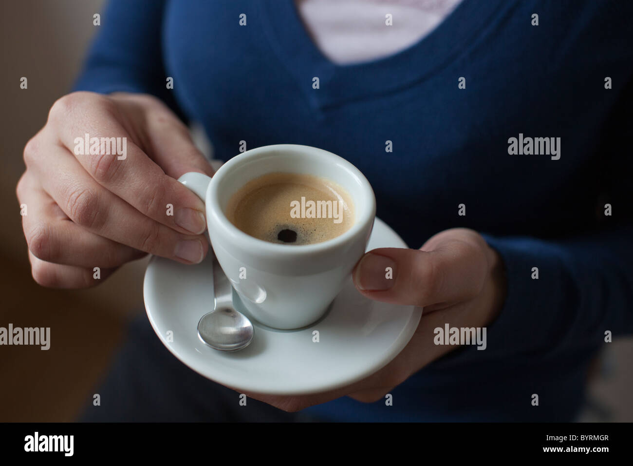 Close-up di una donna con un espresso nelle sue mani Foto Stock
