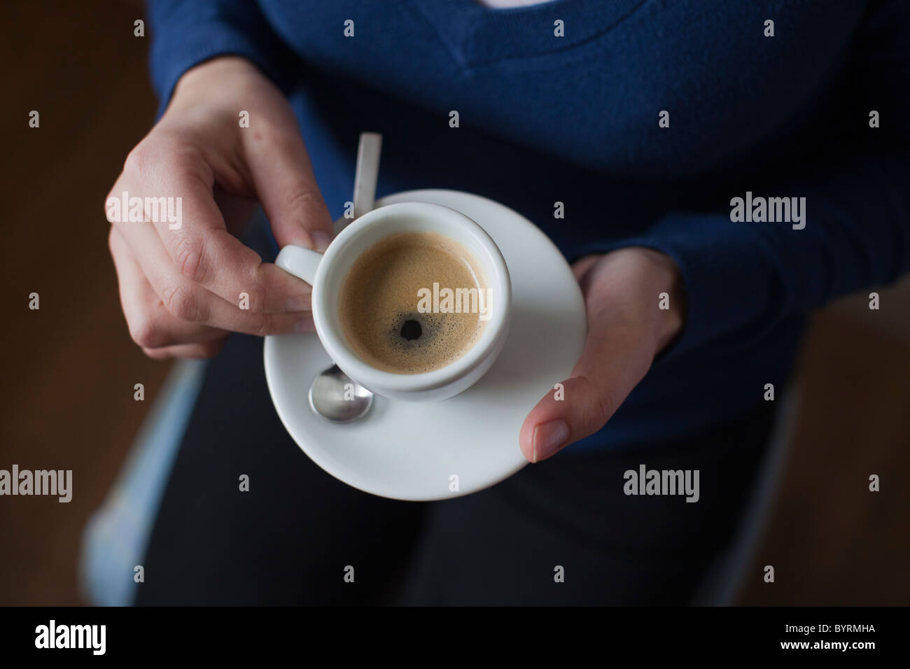 Close-up di una donna con un espresso nelle sue mani Foto Stock