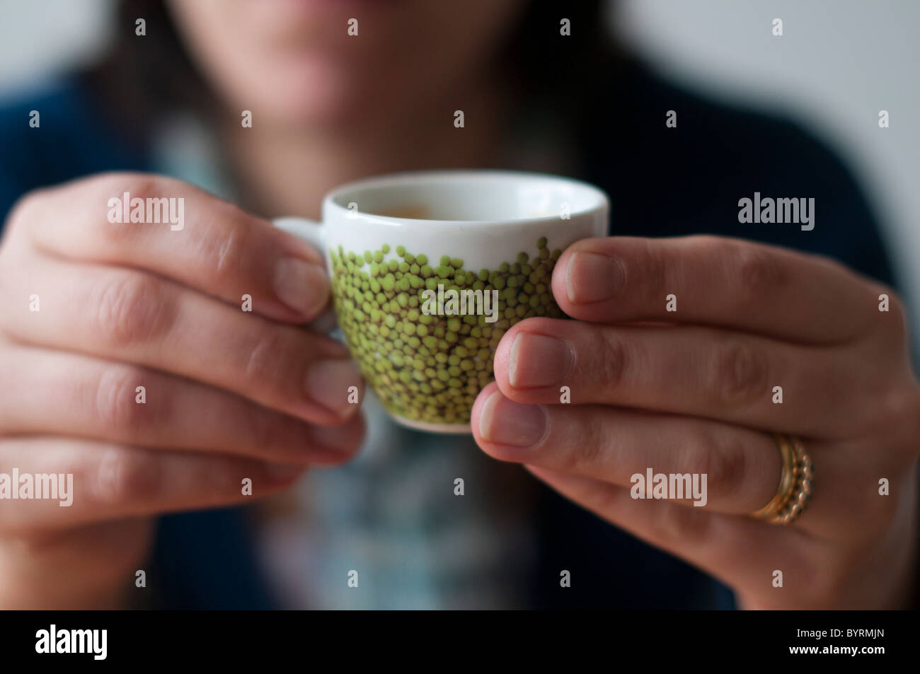 Close-up di una donna con un espresso nelle sue mani Foto Stock