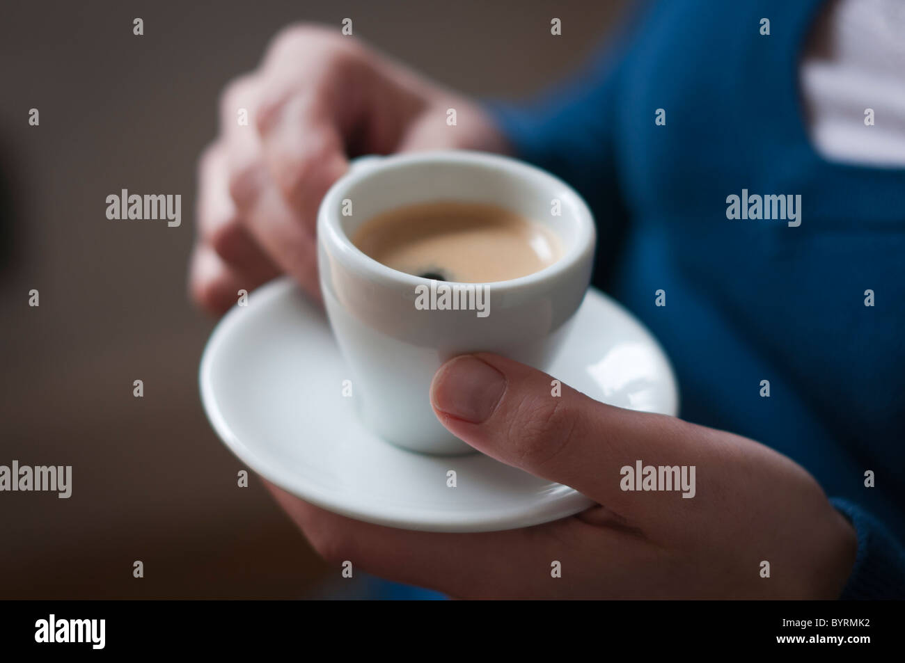 Close-up di una donna con un espresso nelle sue mani Foto Stock