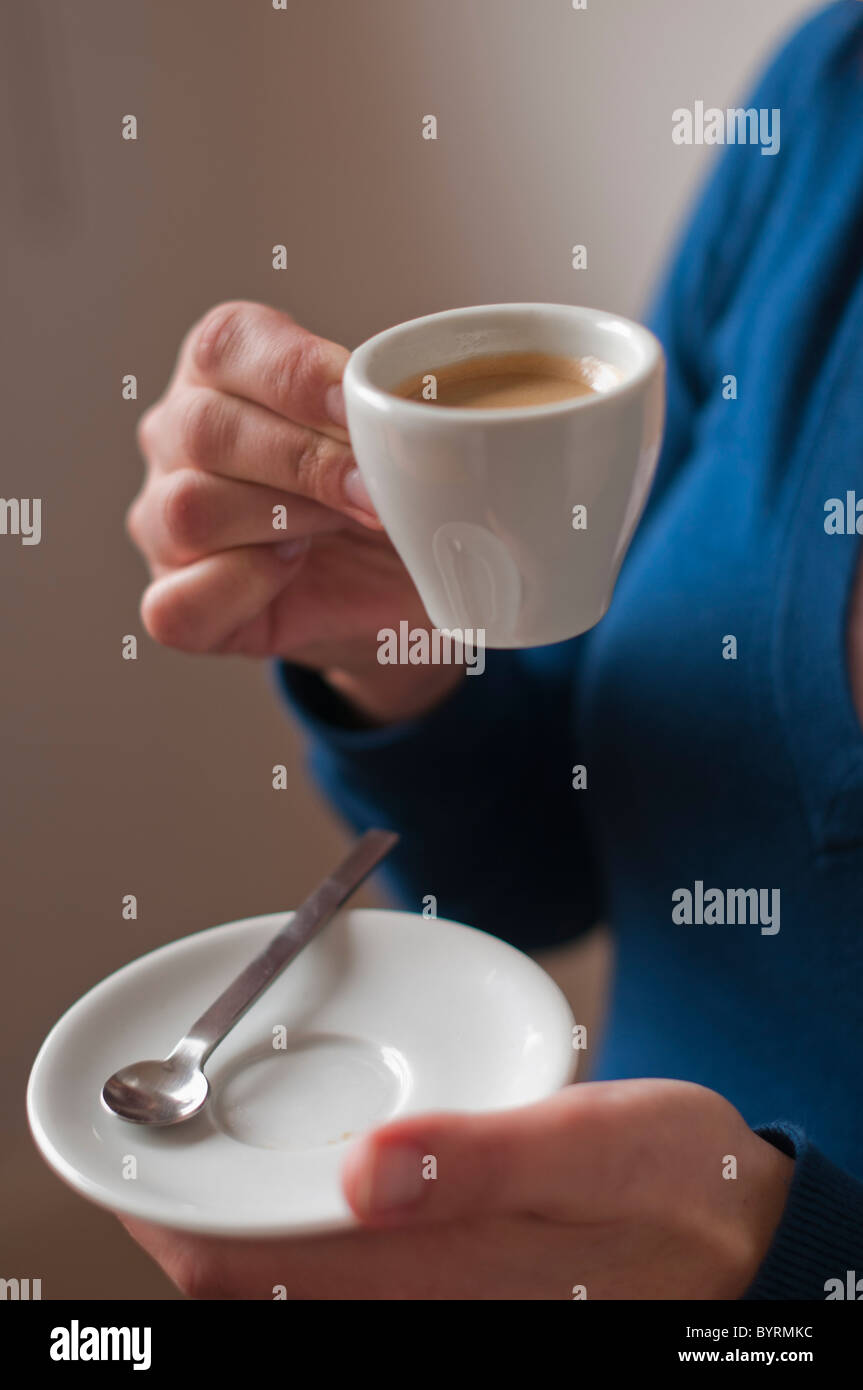 Close-up di una donna con un espresso nelle sue mani Foto Stock