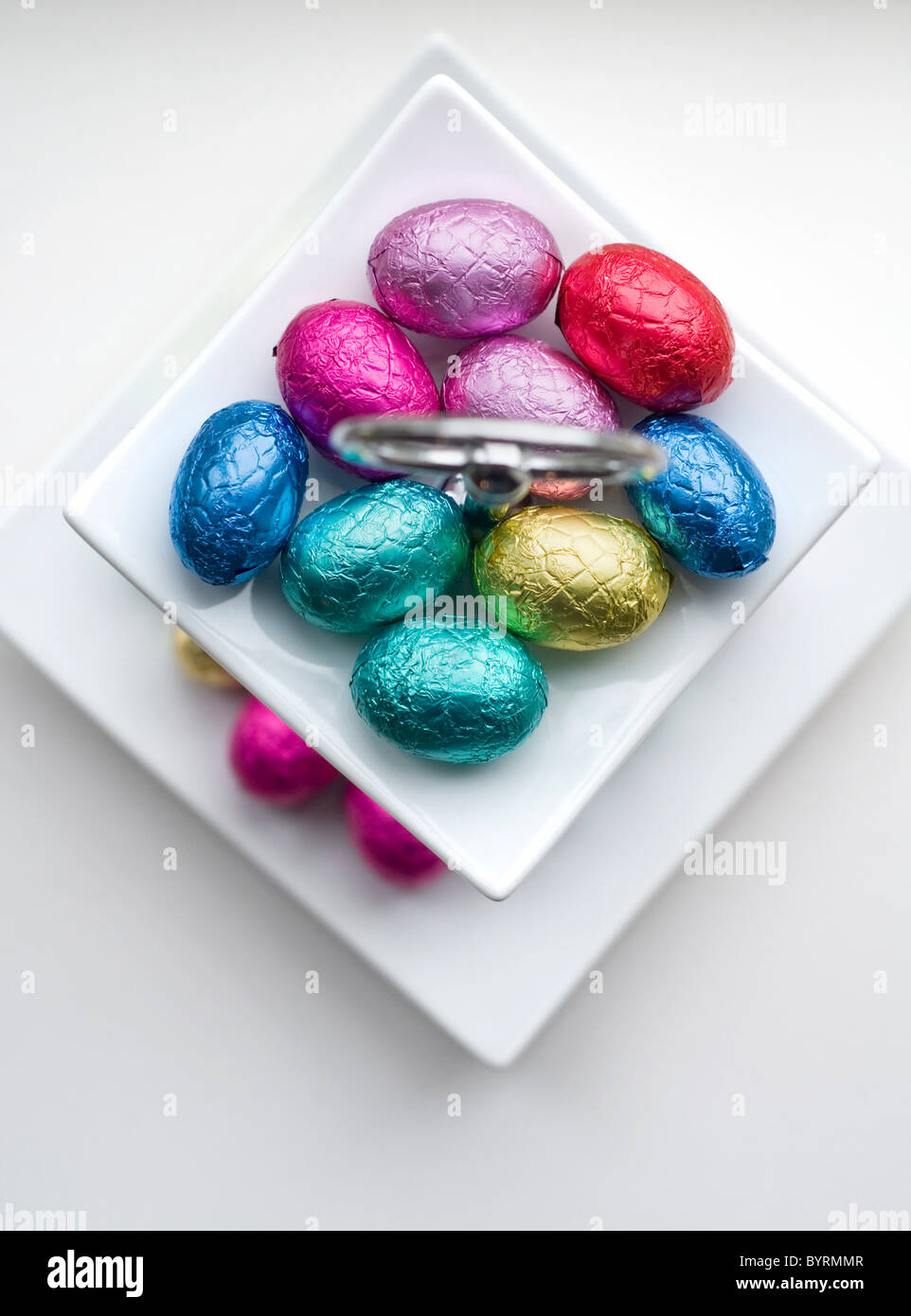 Una piccola selezione di mini uova di cioccolato in un piatto bianco Foto Stock