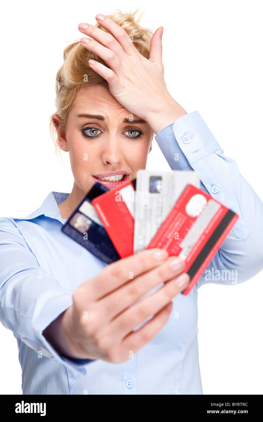 Attraente giovane donna con il debito di denaro e preoccupazioni - ha sottolineato cercando tenendo le carte di credito Foto Stock