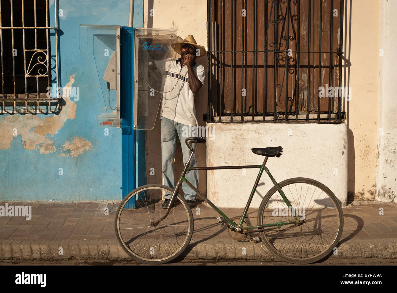 Uomo di effettuare una chiamata da un telefono pubblico, Camaguey, Cuba Foto Stock