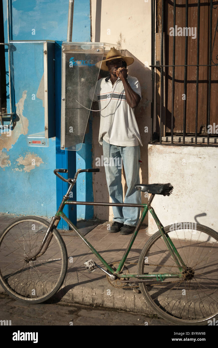 Uomo di effettuare una chiamata da un telefono pubblico, Camaguey, Cuba Foto Stock