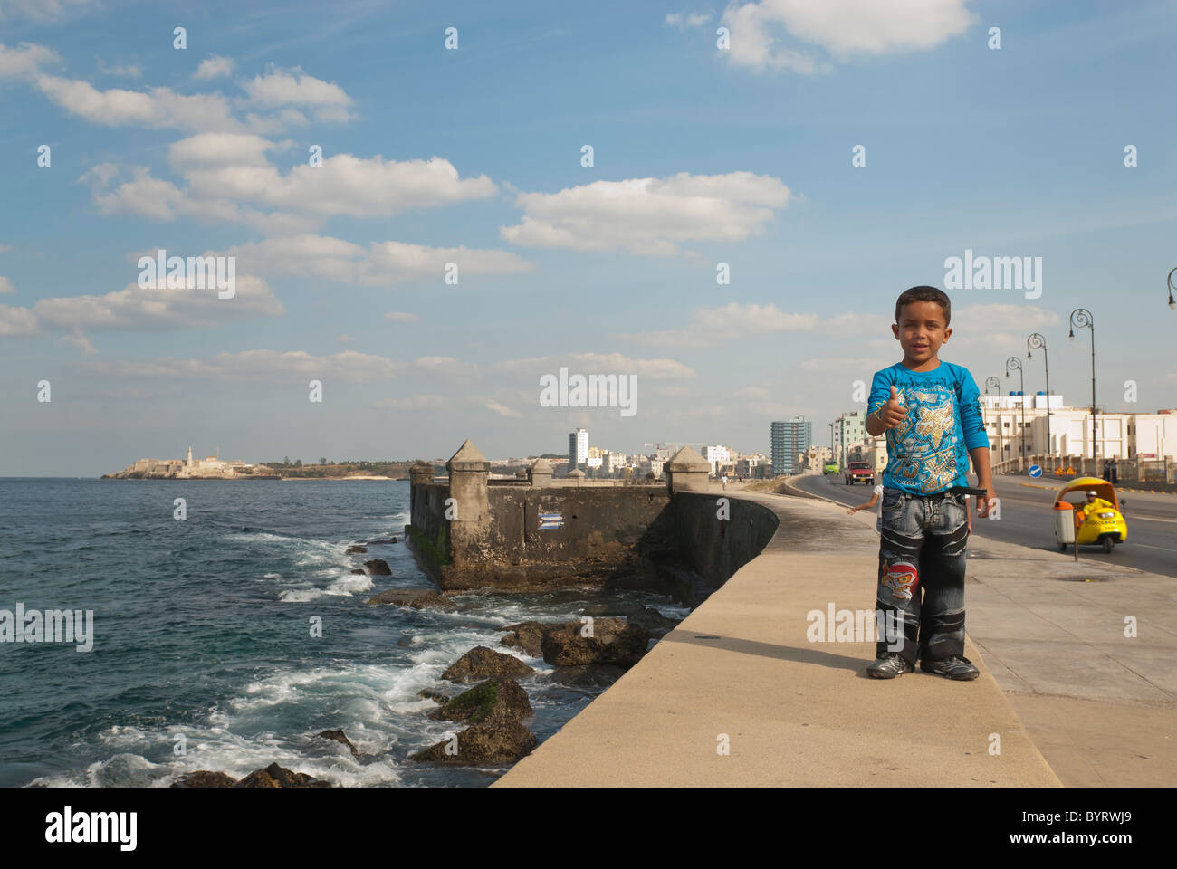 Ragazzo camminando sul Malecon in posa per la fotocamera con il pollice in alto, La Habana, Cuba Foto Stock