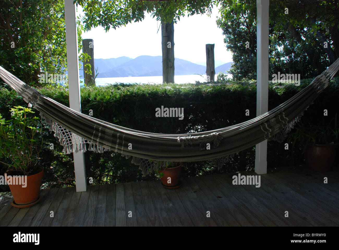 Amaca e vista sui suoni, vicino a Picton in Nuova Zelanda, vista dal balcone del pesce pigro bach (homestead) Foto Stock