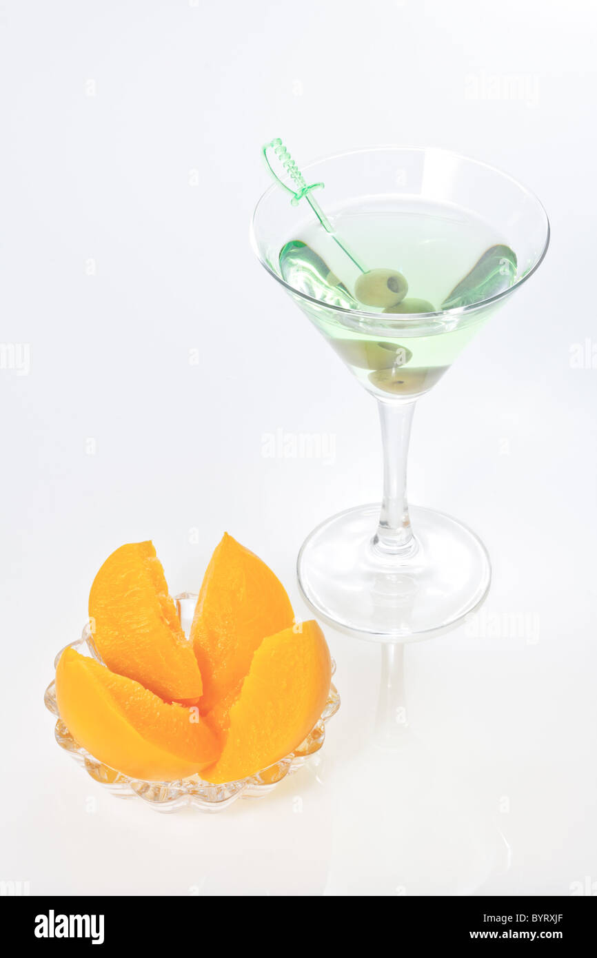 Peach dessert e alcool verde con cocktail martini dry e due olive su spiedino Foto Stock