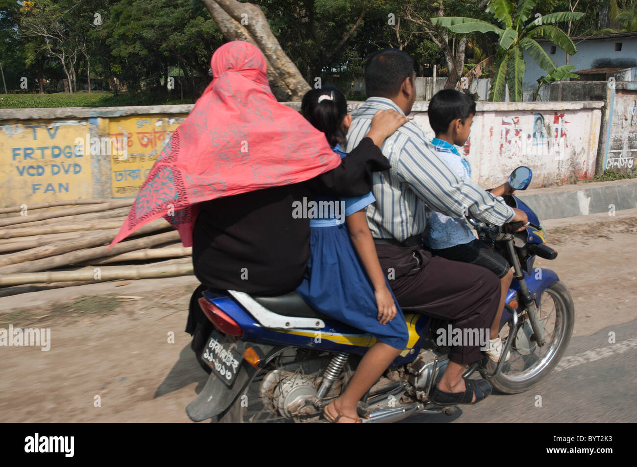 Bengalese famiglia indiana a cavallo su blu Hero Honda Moto, quattro su una bicicletta, padre e figlia della madre e figlio sul serbatoio della benzina Foto Stock