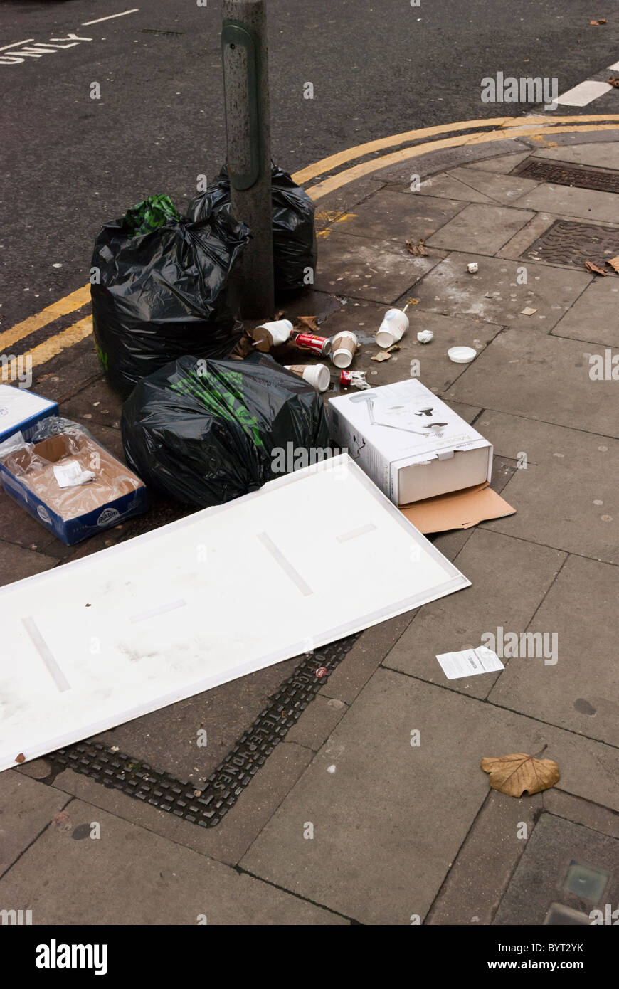 Rifiuti sinistra sul marciapiede della Danimarca Street, Londra, WC2 Foto Stock