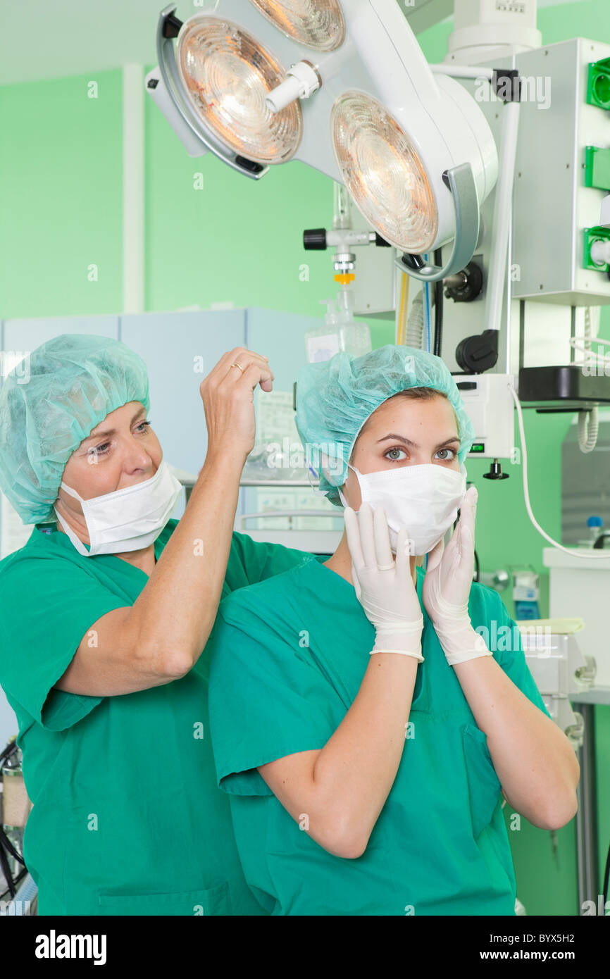 Gli infermieri in scrubs aiutando con maschera Foto Stock