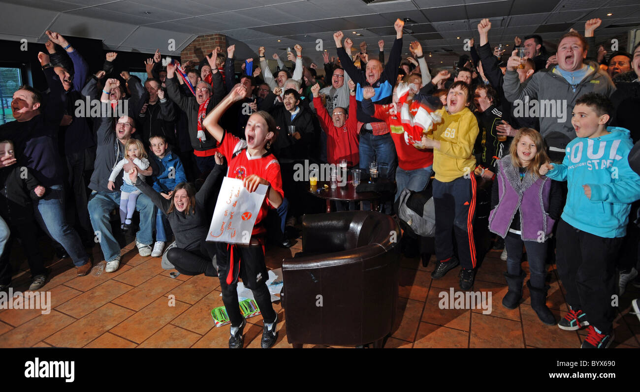 Crawley Town tifosi festeggiare selvaggiamente come il loro team è tirato fuori a giocare il Manchester United nel quinto round di FA Cup Foto Stock