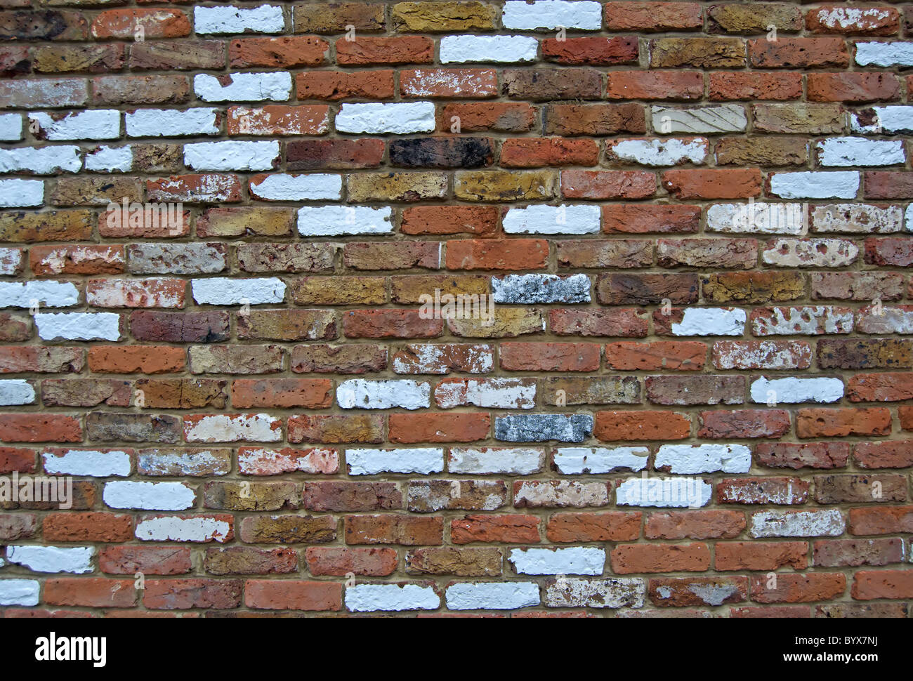 Parete in mattoni costruito con mattoni riciclati di varie condizioni e colore, a Teddington, Middlesex, Inghilterra Foto Stock