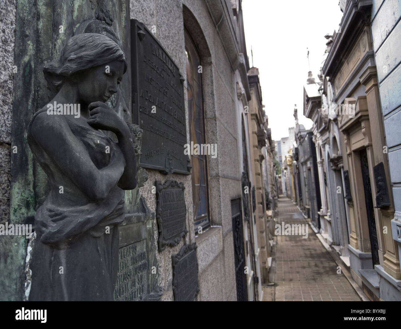 Malinconici statua della ragazza guarda giù dalla sepoltura vault, Recoleta cimitero, Buenos Aires, Argentina. Foto Stock