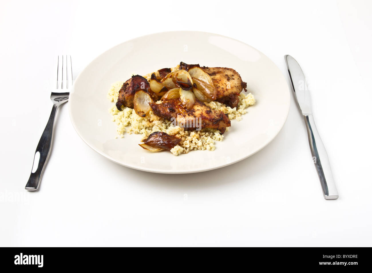 Marocchino Pollo speziato con couscous e cipolle isolato su bianco. Foto Stock
