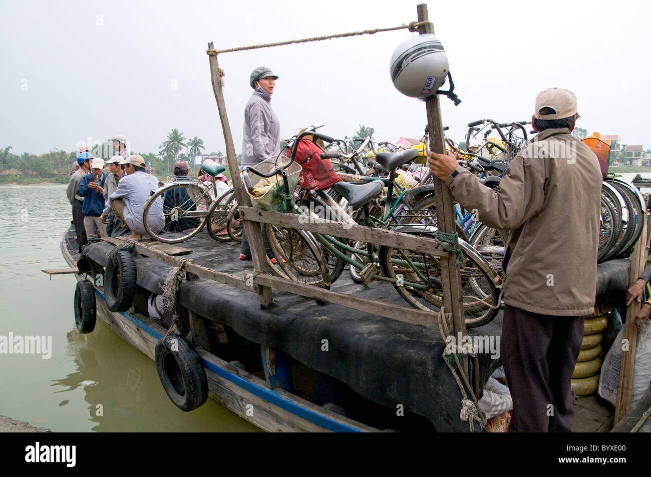 Il Vietnam il caricamento di scooter e biciclette di una chiatta per attraversare il fiume a Hoi An Foto © Julio Etchart Foto Stock