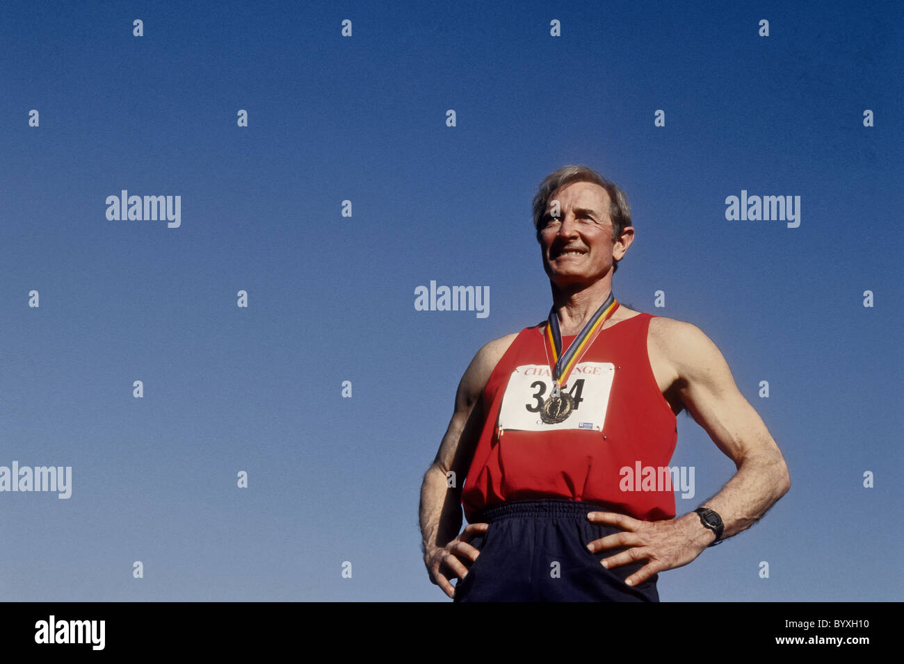 Maschi anziani via e atleta di campo con la sua medaglia d'oro. Foto Stock