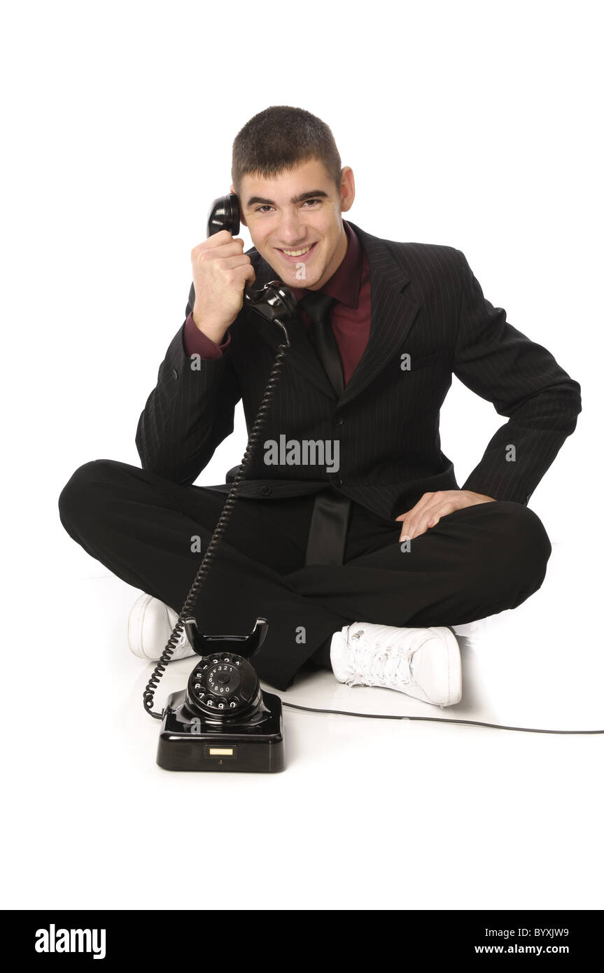 Giovane uomo in tuta con mobili antichi di chiamate telefoniche Foto Stock