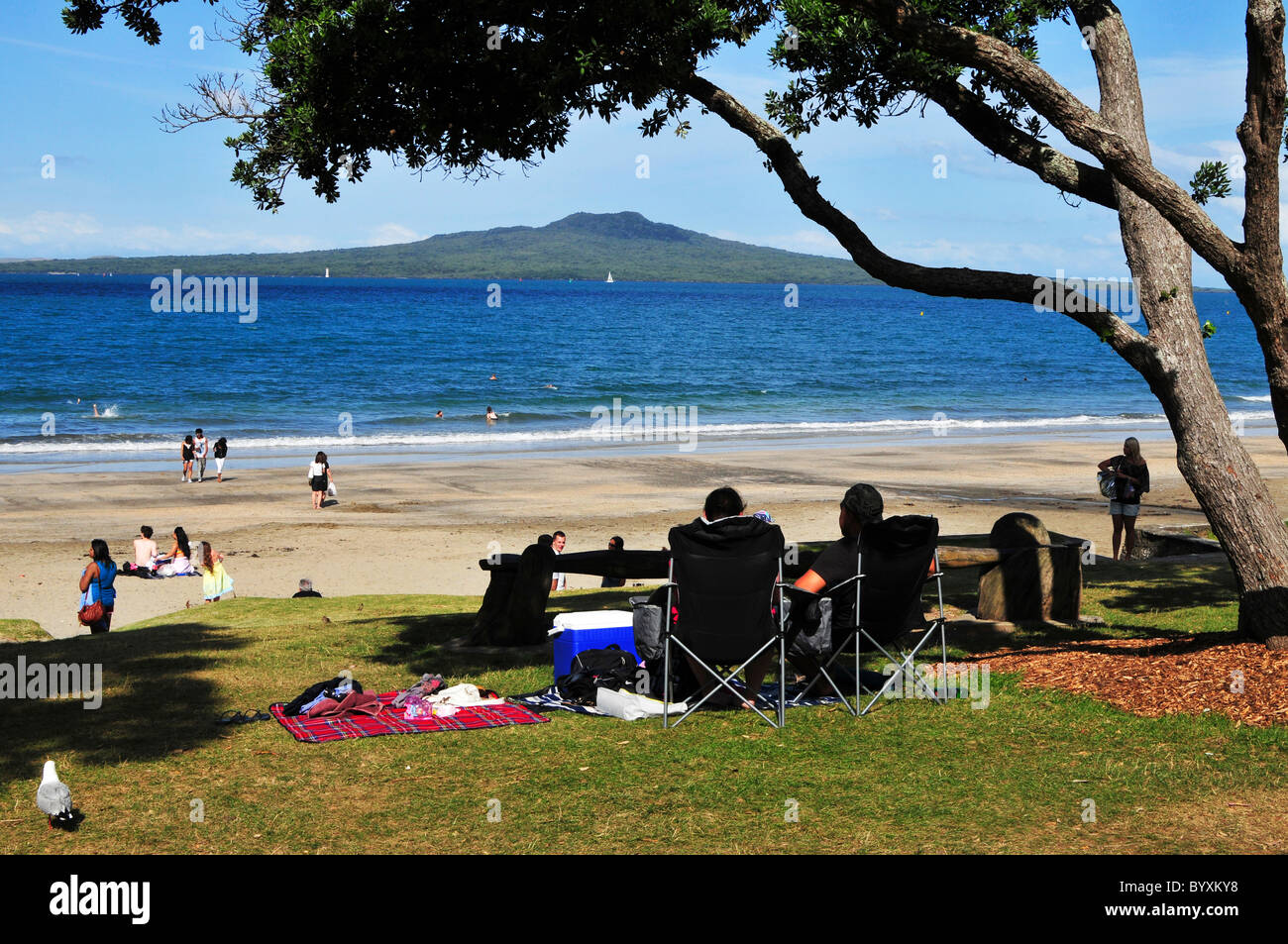 Takapuna Beach e si affaccia sull'Isola di Rangitoto, un vulcano estinto vicino alla città di Auckland in Nuova Zelanda. Foto Stock