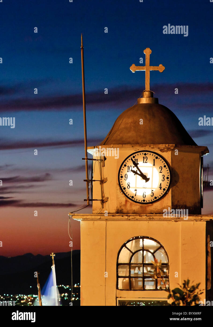 Vecchia chiesa orologio contro il tramonto in Grecia Foto Stock