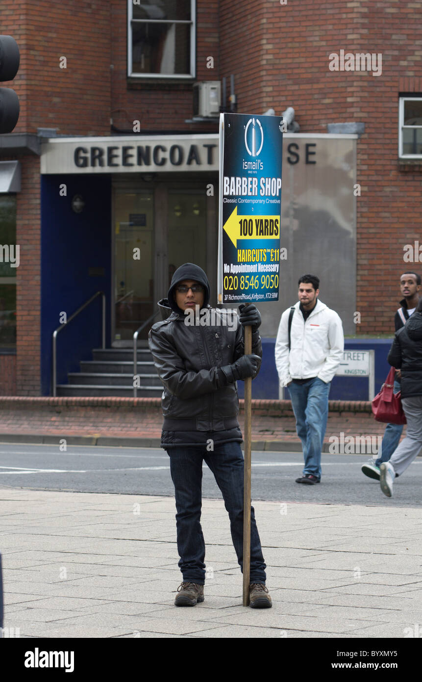 Uomo con un pannello pubblicitario al di fuori di Kingston, alla stazione ferroviaria di Londra Foto Stock Uomo con un pannello pubblicitario al di fuori di Kingston, alla stazione ferroviaria di Londra Foto Stock
