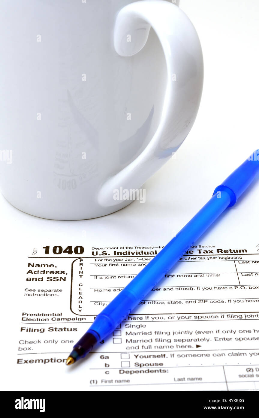 Imposta di IRS Form 1040 con penna a inchiostro e tazza di caffè isolato su sfondo bianco. Foto Stock