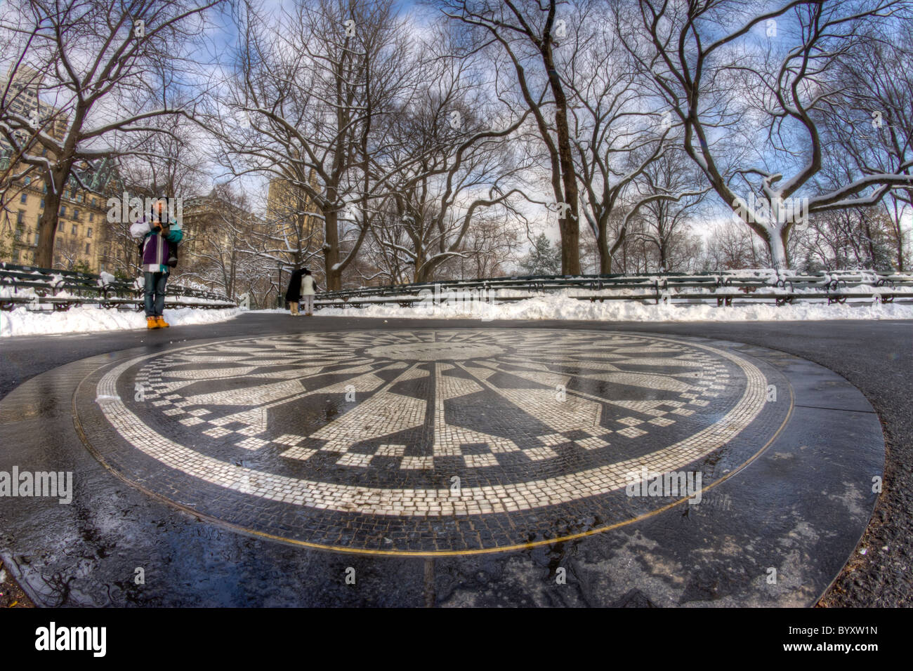 Un giovane uomo guarda la immaginate di mosaico in Strawberry Fields a Central Park su un pomeriggio nevoso Foto Stock