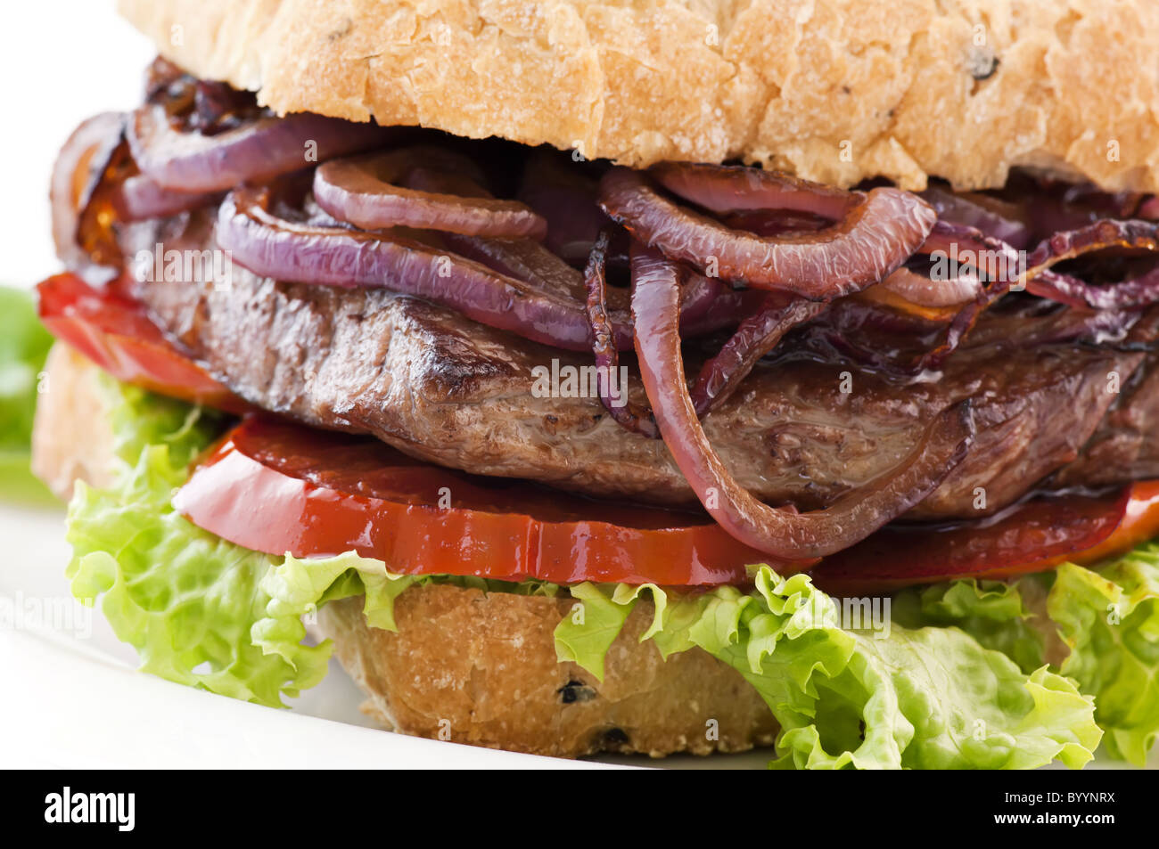 Hamburger di manzo con bistecca di manzo, anelli di cipolla e tomotos come closeup su sfondo bianco Foto Stock