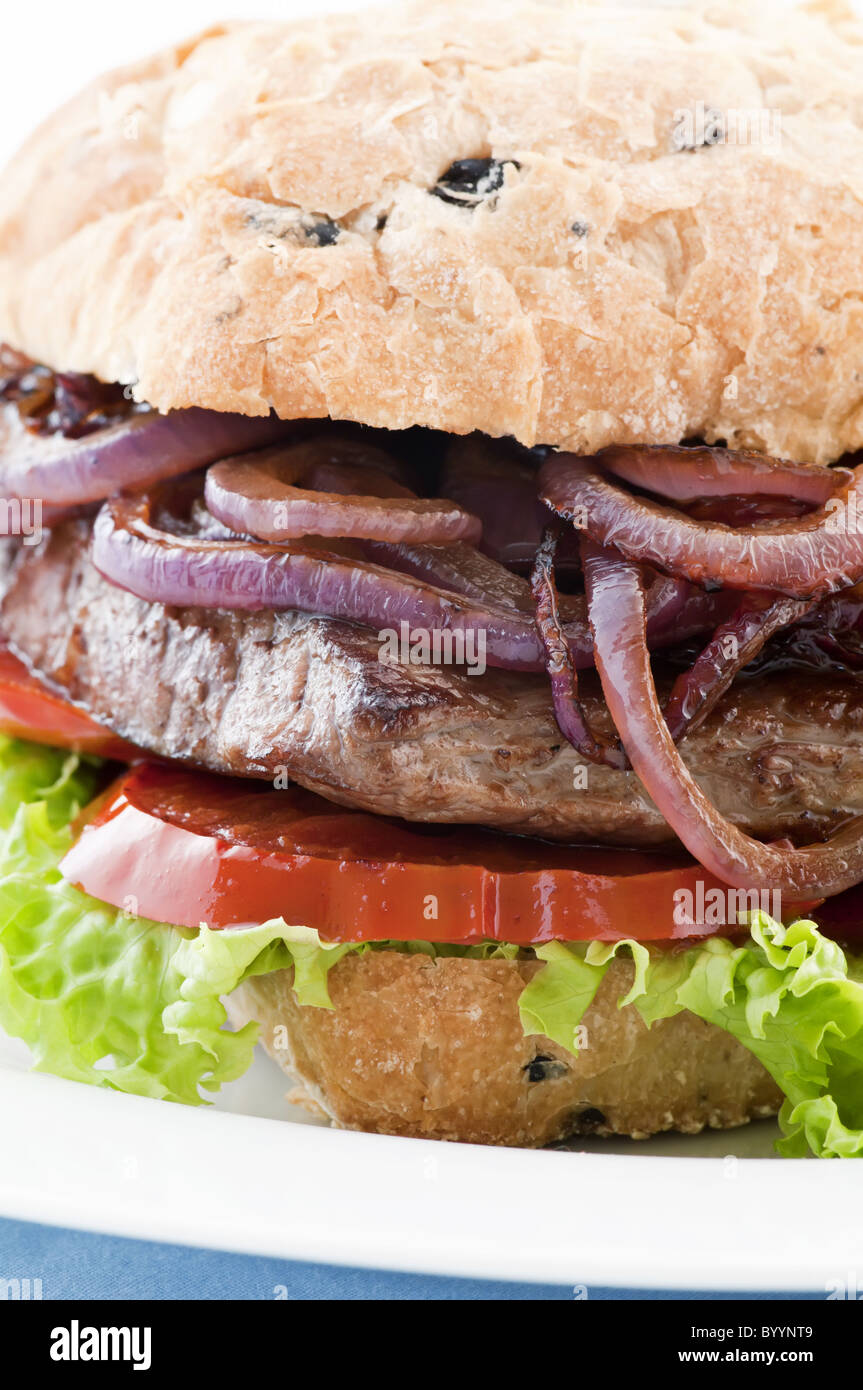 Hamburger di manzo con bistecca di manzo, anelli di cipolla e tomotos come closeup su sfondo bianco Foto Stock
