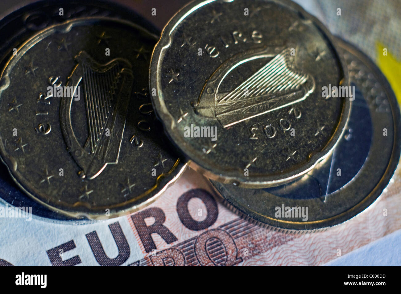 Monete metalliche in euro con l arpa irlandese simbolo poggiano su una cinquantina di euro nota Foto Stock