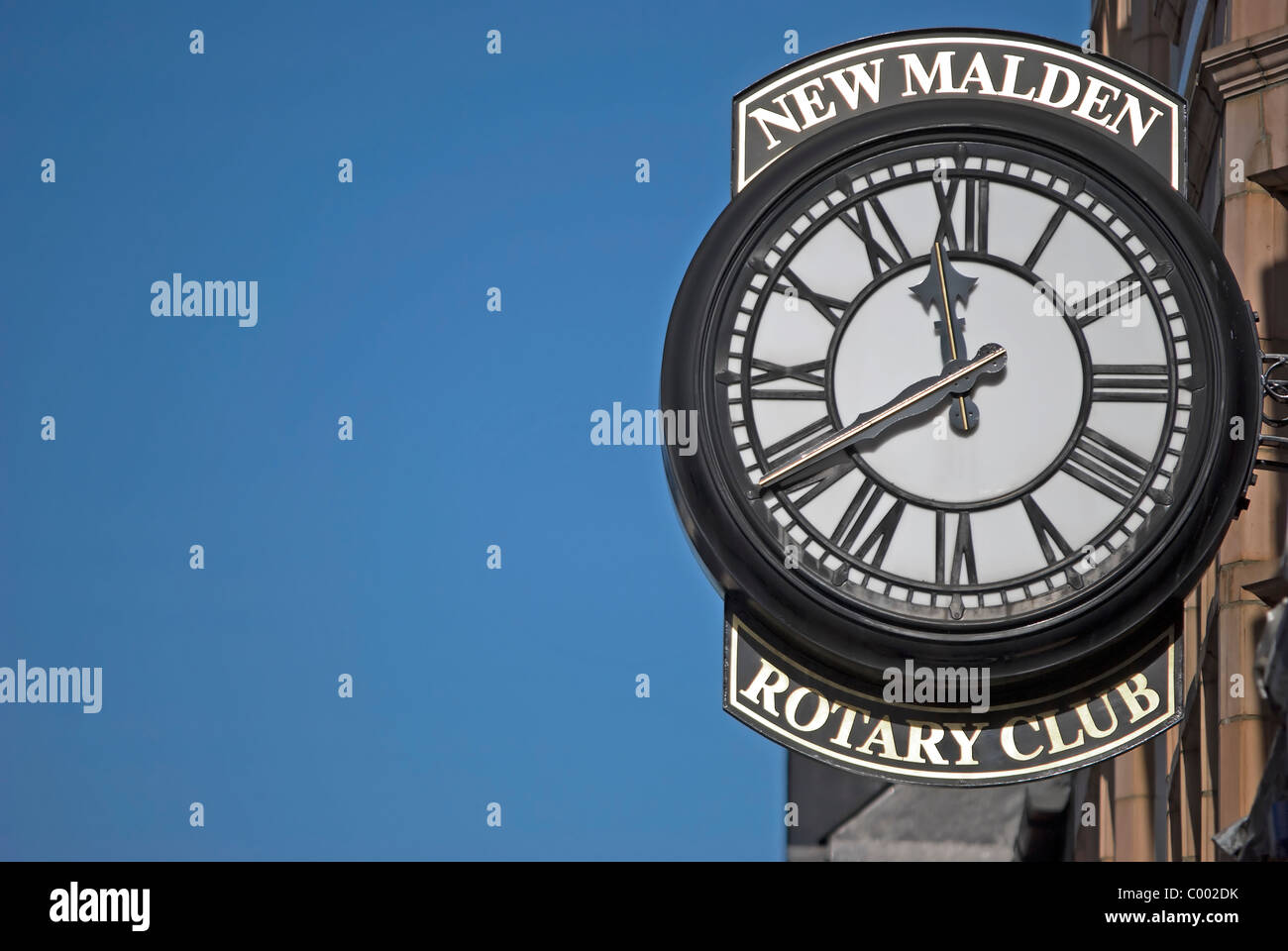 Orologio con numeri romani al di fuori del Rotary club di New Malden Surrey, Inghilterra Foto Stock