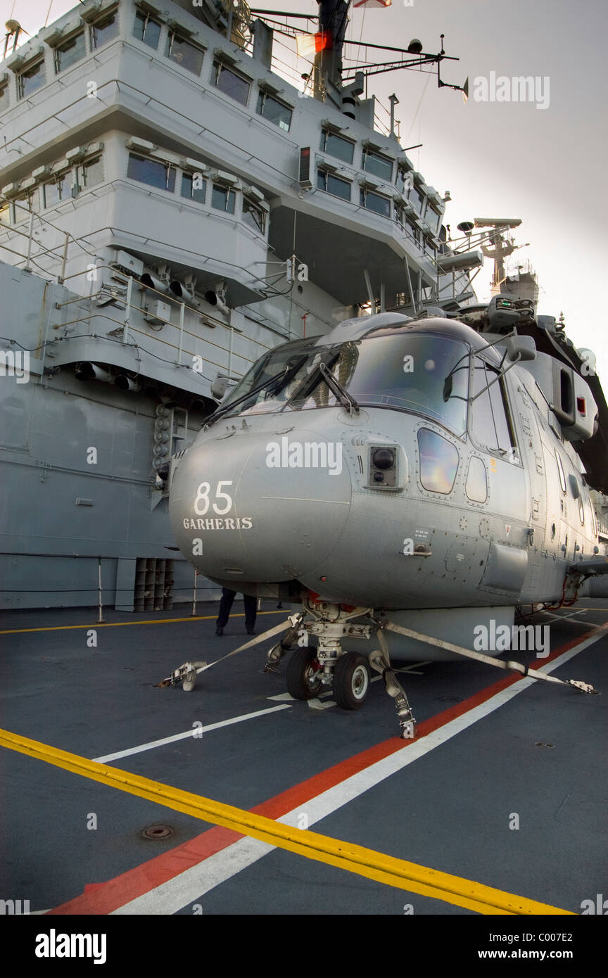 Un elicottero Merlin sul per'd sollevare circa per la discesa alla staffa del British portaerei HMS Ark Royal Foto Stock