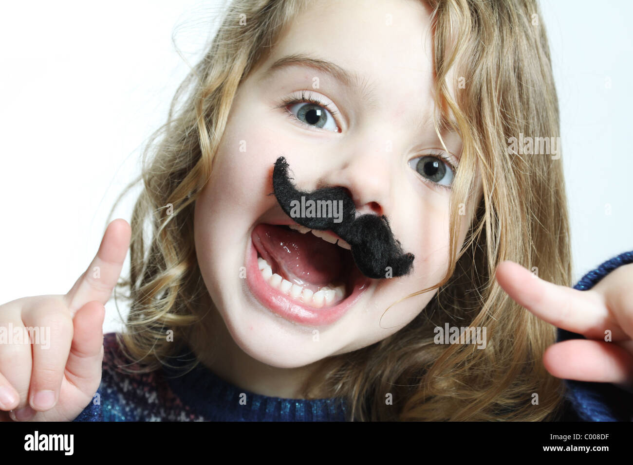 Un po' di bianco ragazza caucasica puntando al suo fake baffi neri, felice con la bocca aperta. Foto Stock