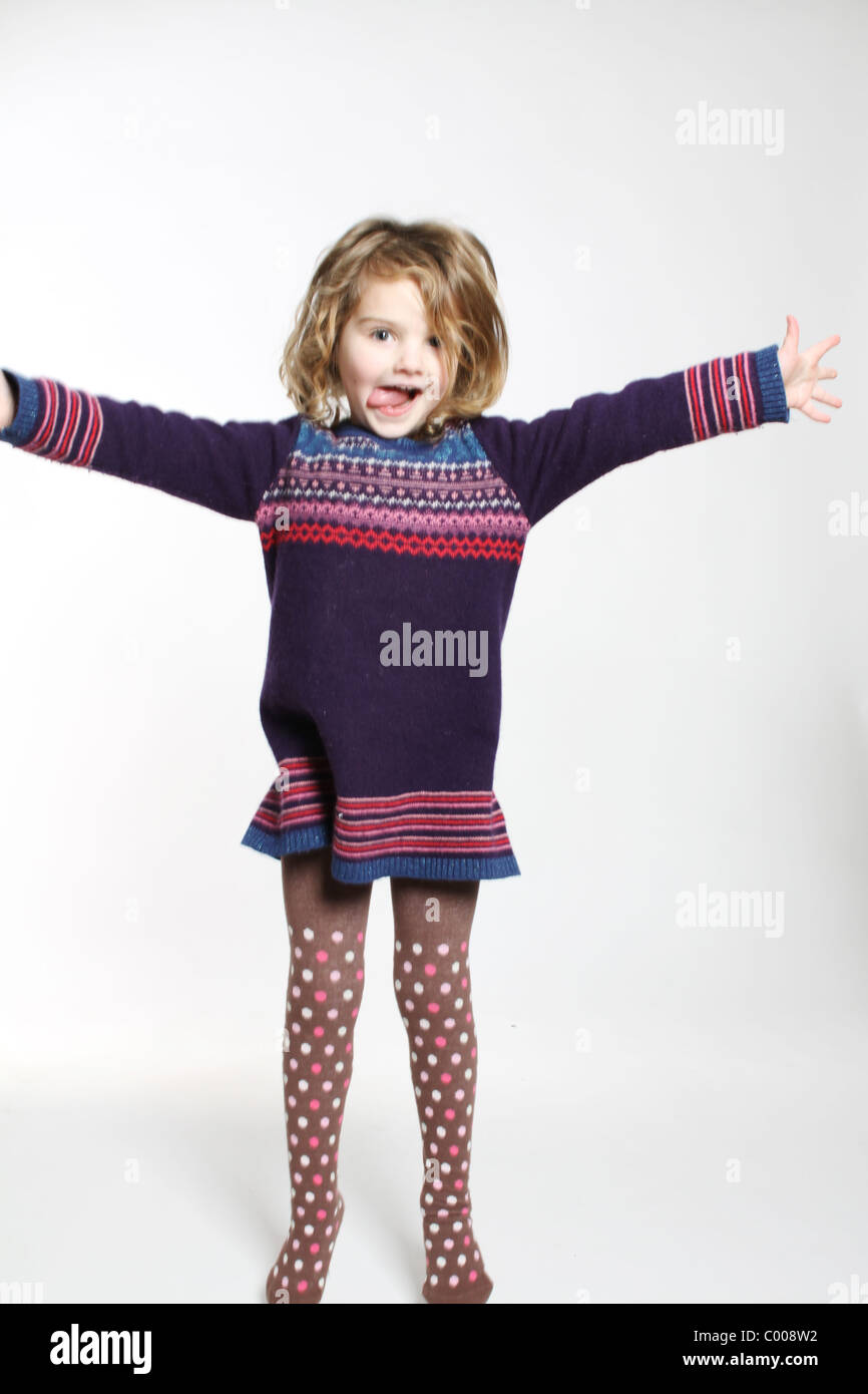 Poco quattro anno vecchia ragazza jumping in lana abito a ponticello Foto Stock