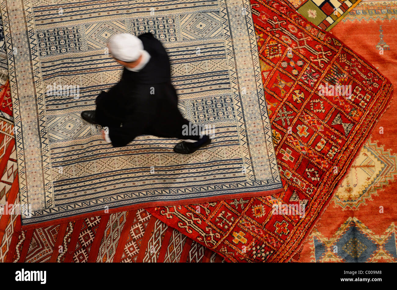 Riad Marocchino proprietario shopping per un nuovo tappeto persiano in Fes el Bali medina marocco Foto Stock