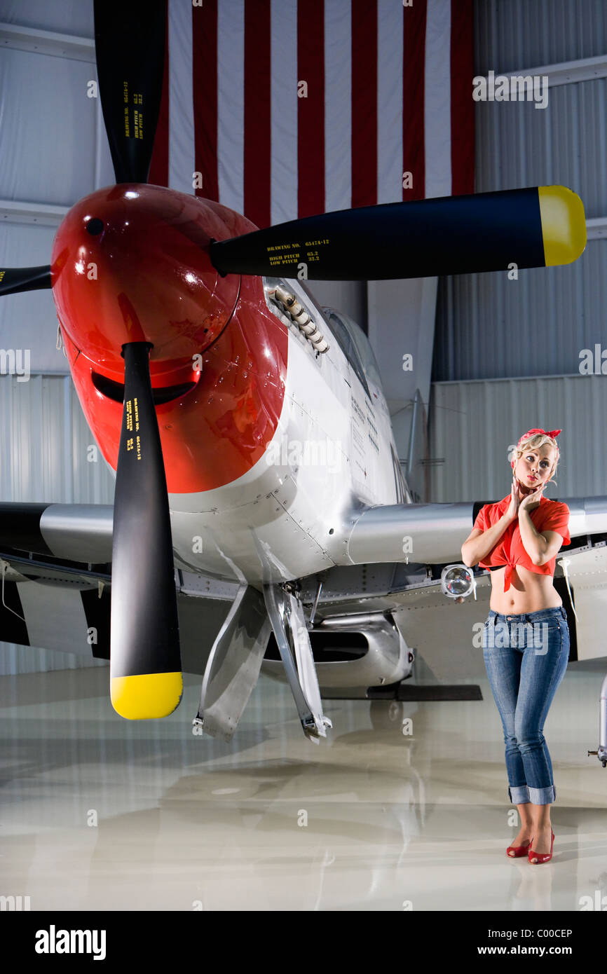 Sexy ragazza in piedi accanto al vintage aereo da caccia Foto stock - Alamy