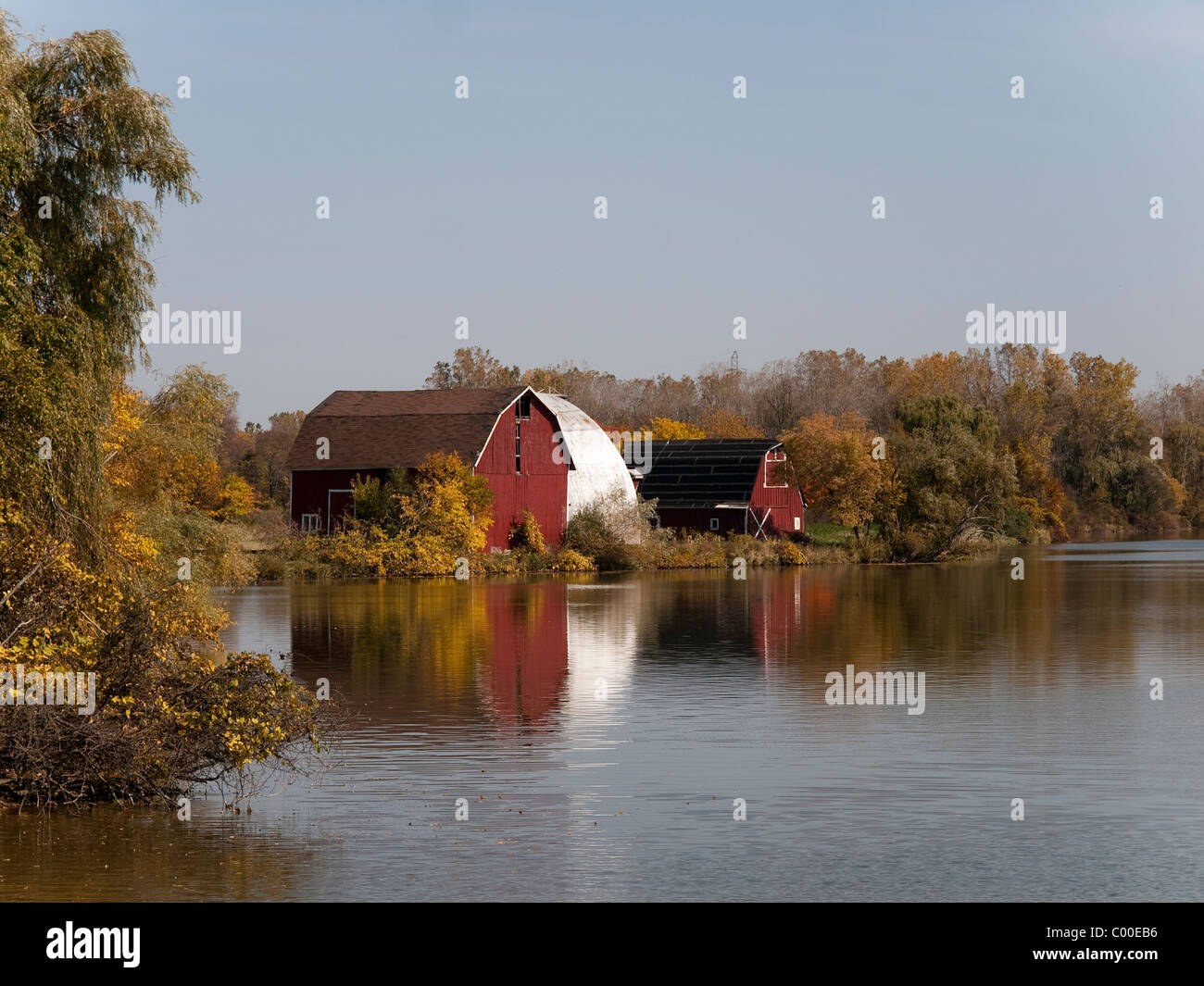 Antica fattoria di edifici con granaio rosso lungo la riva del lago Mott a Huckleberry ferrovia nel Michigan. Foto Stock
