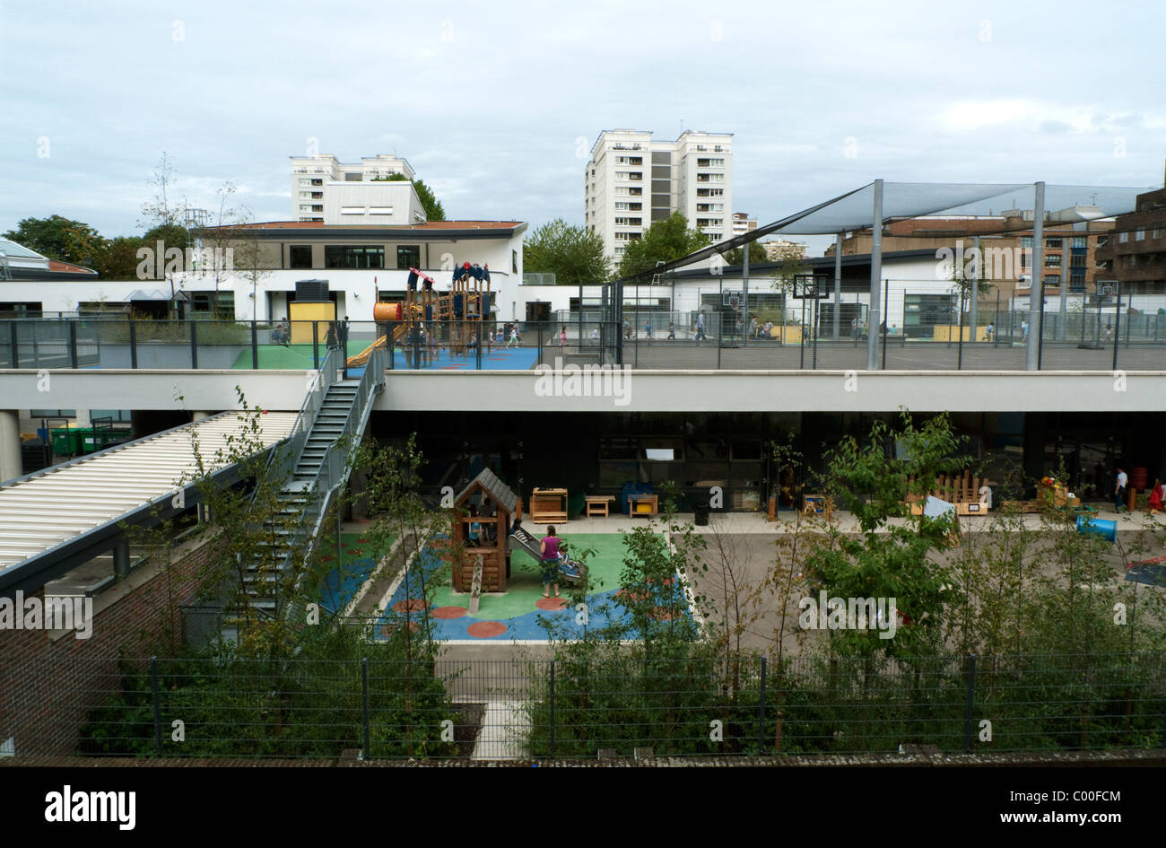 I bambini giocano nel colorato parco giochi della scuola del Prior Weston Golden Lane Campus vicino alla Barbican Estate, Islington, Londra EC1 Inghilterra Regno Unito KATHY DEWITT Foto Stock