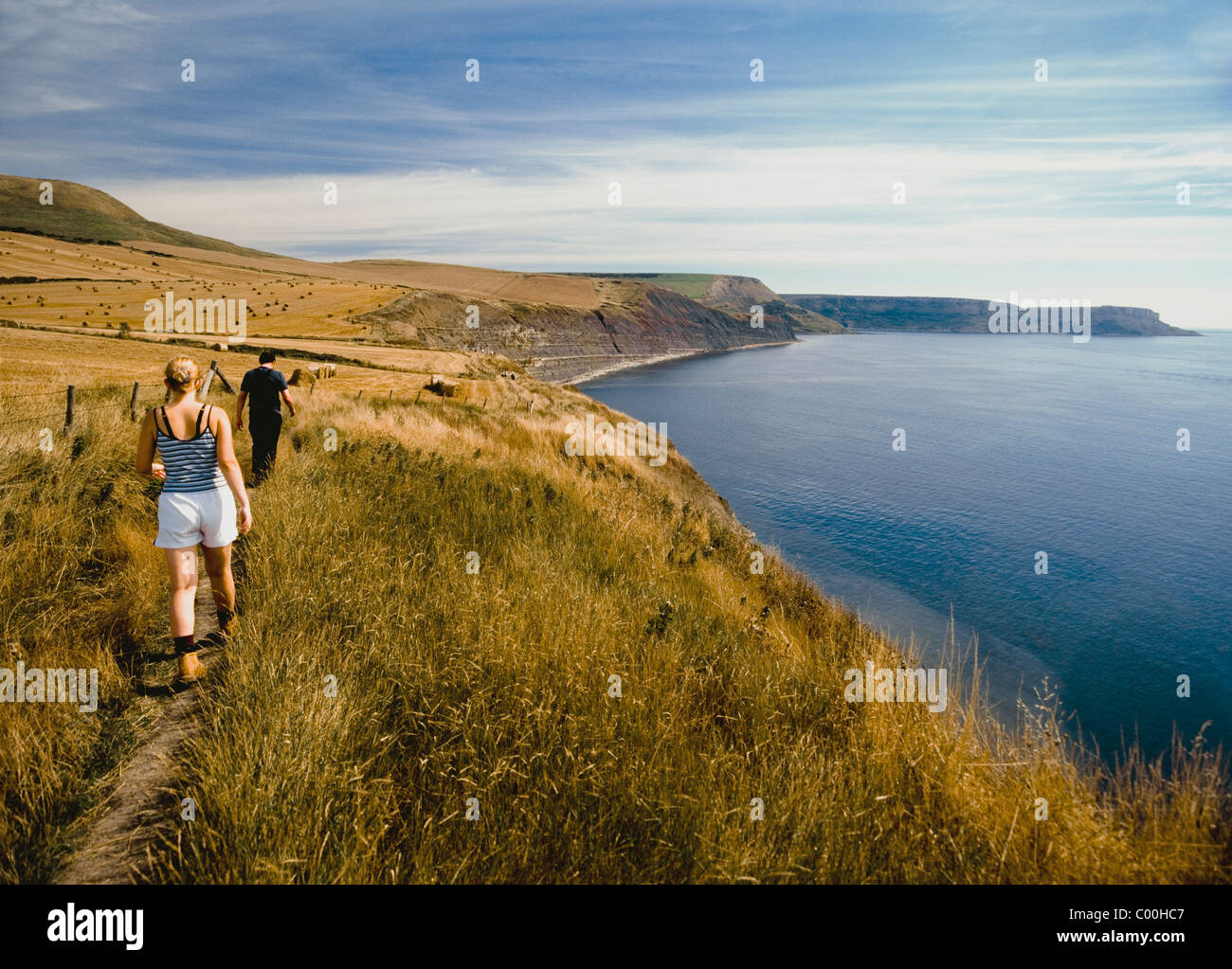 Cauple camminando lungo il sentiero costiero, vista posteriore Foto Stock
