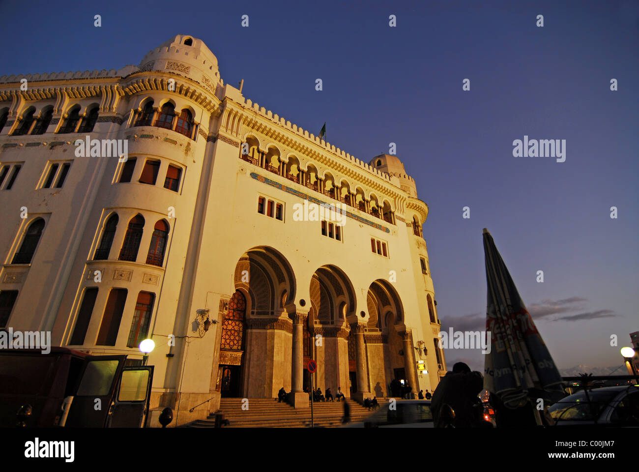 Algeria, Alger, basso angolo di visione delle persone da post office edificio contro il cielo al tramonto Foto Stock