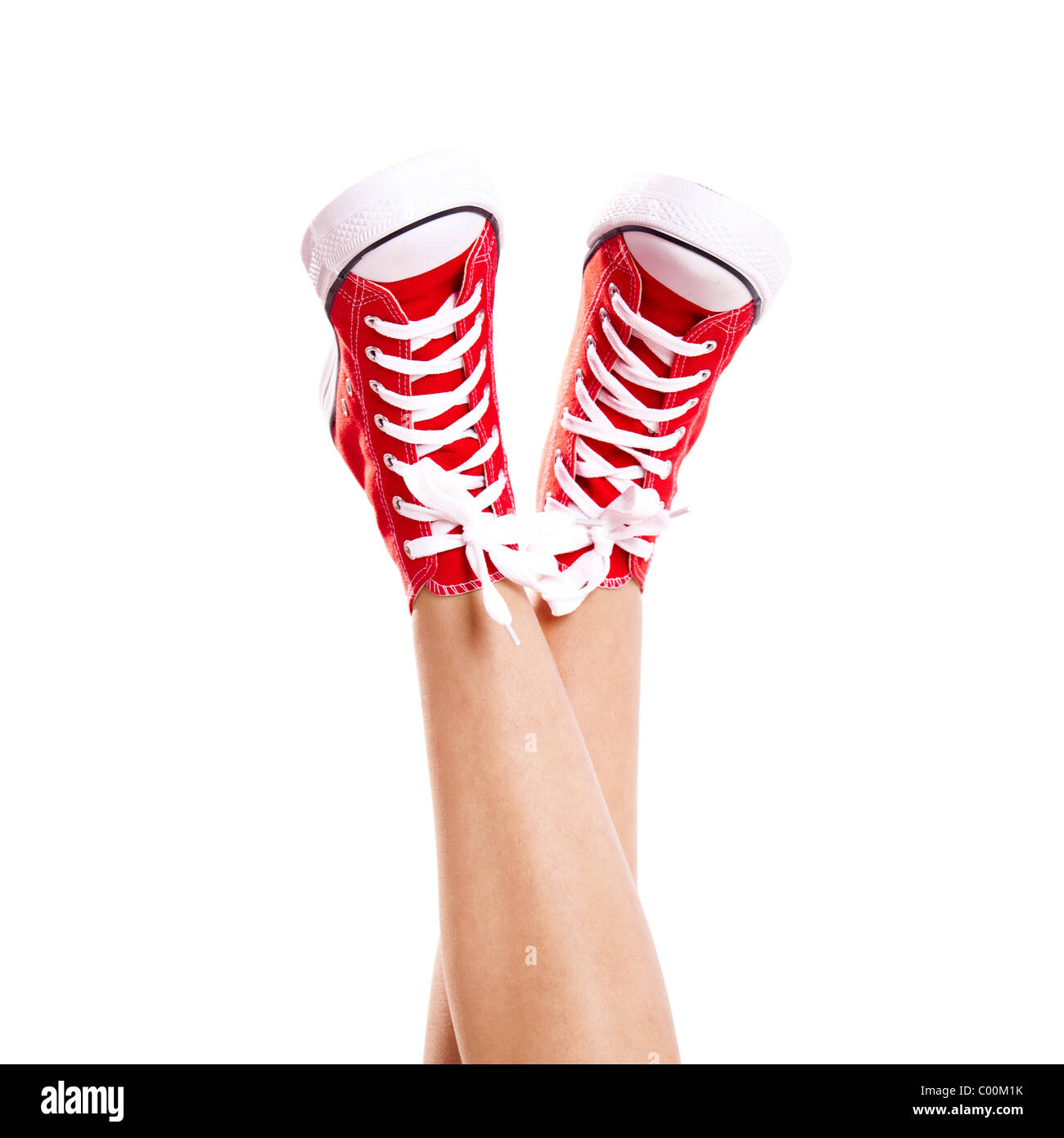 In prossimità delle gambe di una donna che indossa un paio di scarpe da ginnastica  rosse, isolato su bianco Foto stock - Alamy