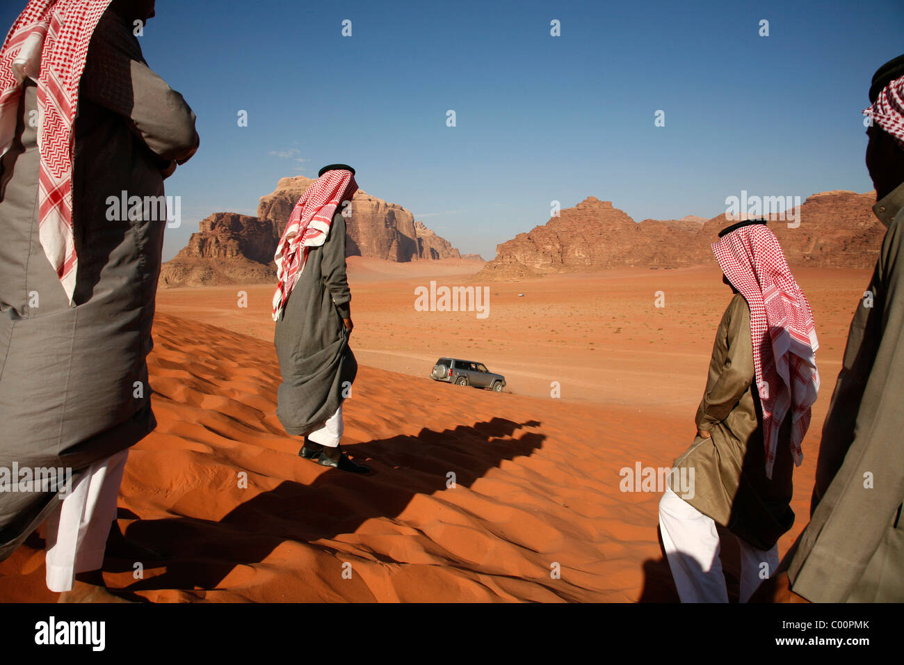 La gente araba e una jeep su una rossa duna di sabbia nel Wadi Rum, Giordania. Foto Stock