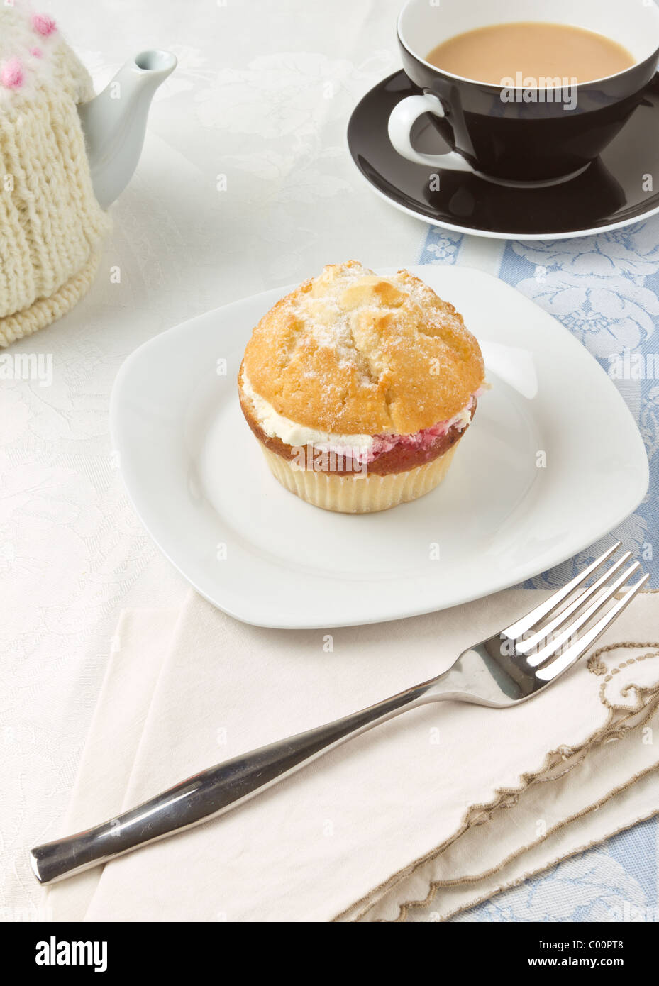 Il tè del pomeriggio con crema di lamponi e riempito di muffin. Foto Stock