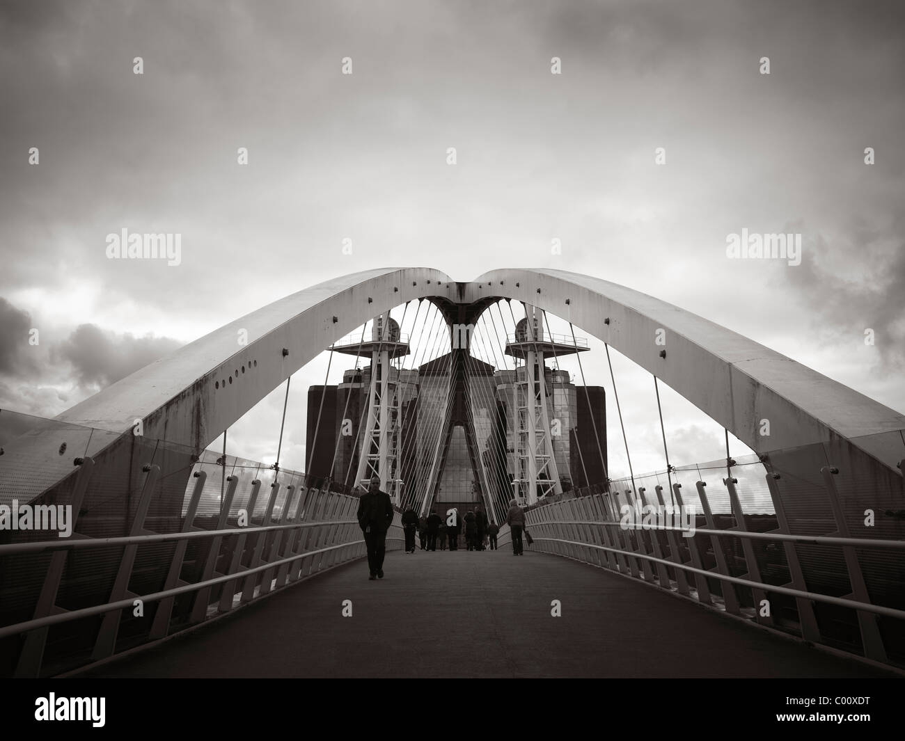 Ponte di Lowry Salford Quays con persone che camminano con moody sky in bianco e nero Foto Stock