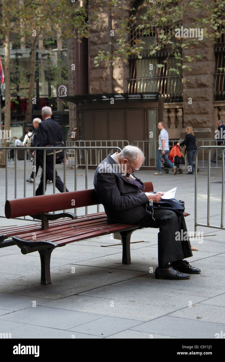 Un anziano gentiluomo dorme su una panchina di Martin Place, Sydney, su Anzac Day 2010. Nuovo Galles del Sud, Australia. Foto Stock