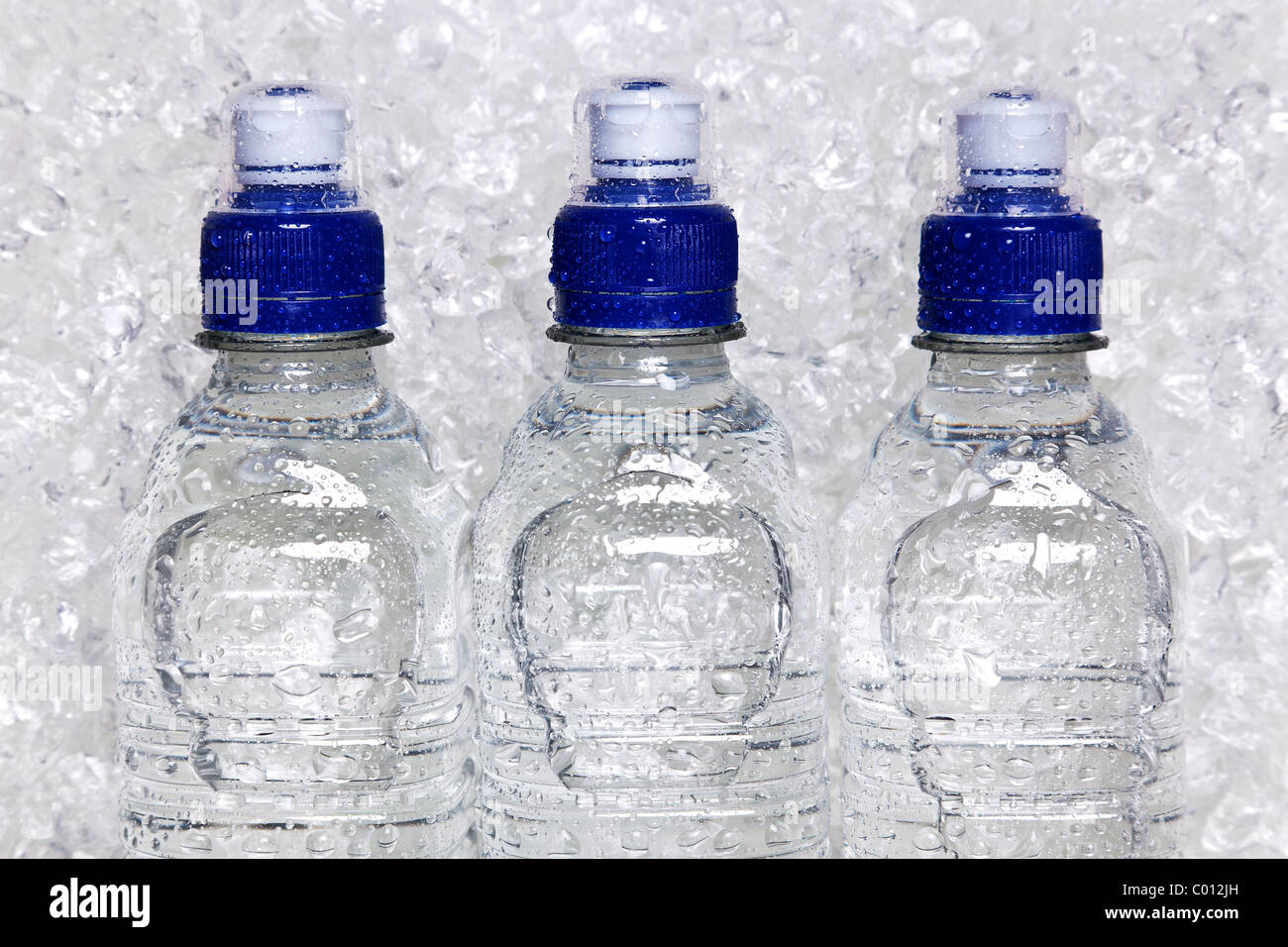 Foto di acqua minerale fredda in bottiglie di plastica sul ghiaccio tritato Foto Stock