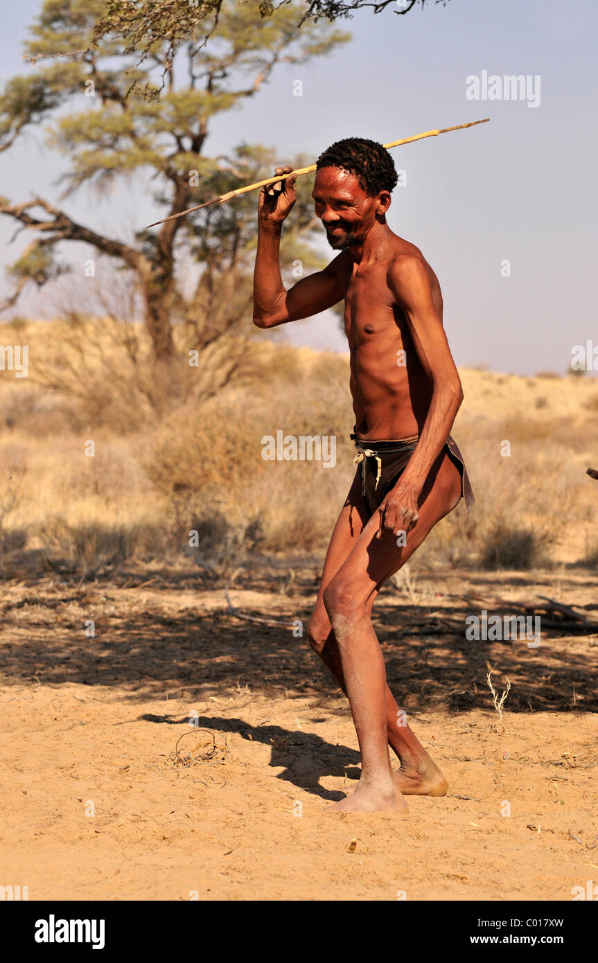 L'uomo della tribù Khomani-San con lancia e abito tradizionale nel Kalahari, Sud Africa e Africa Foto Stock